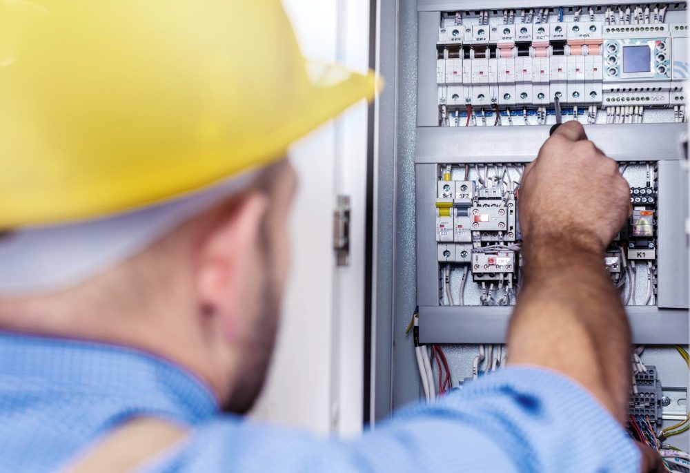 Male electrician hand tunes multimeter probe equipment